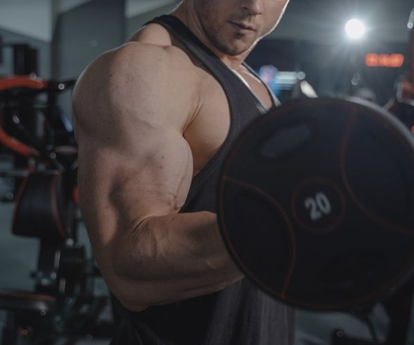 Focused man lifting weights with proper form in a calm environment.